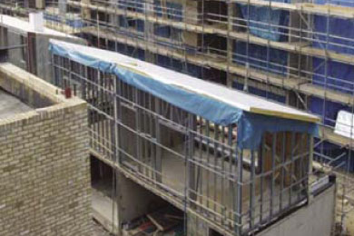 Light steel frame walk-ways showing balcony parapets, window openings, cement particle board sheathing and roof joist over-hang.