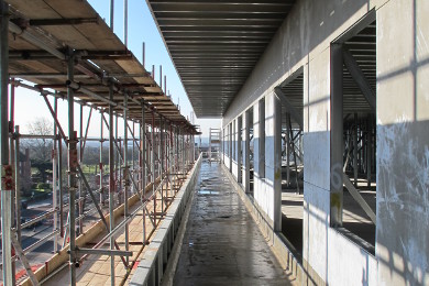 Light steel frame walk-ways showing balcony parapets, window openings, cement particle board sheathing and roof joist over-hang.